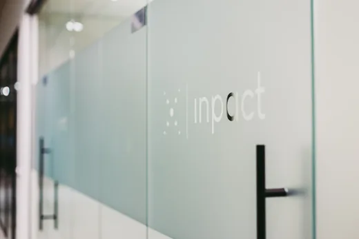 Het Inpact-beeldmerk op een glazen kantoorwand