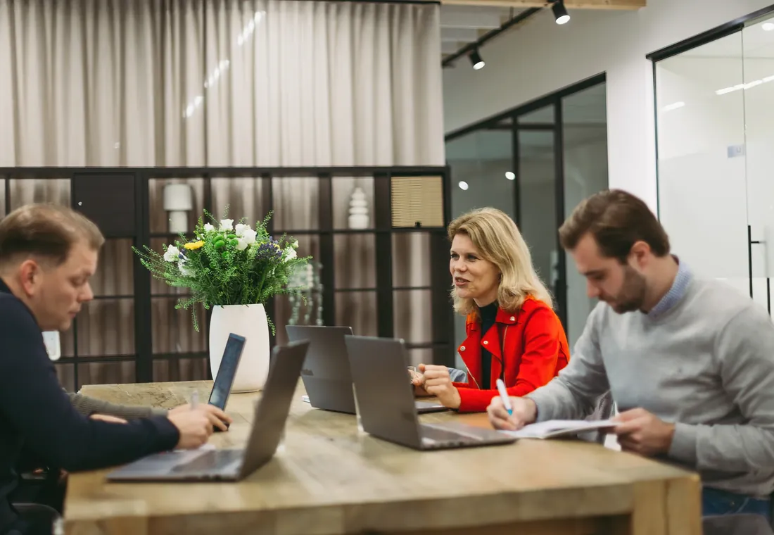 Collega's van Inpact werken samen aan tafel